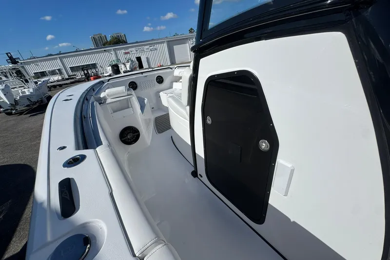 Slide: The Image of 2026 Tidewater 302 CC Adventure boat interior with seating and storage, docked under clear skies. - 32