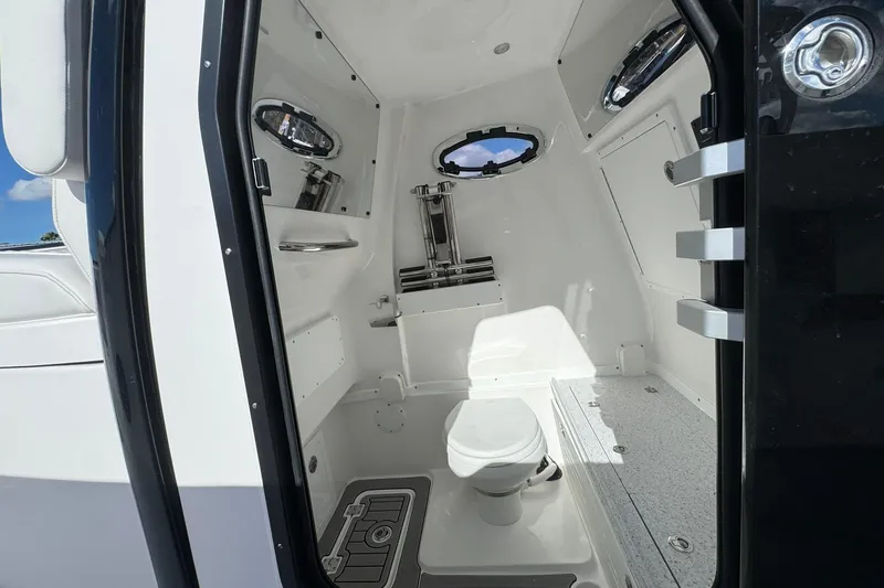 Slide: The Image of Interior of 2026 Tidewater 302 CC Adventure boat, featuring a compact marine toilet. - 33