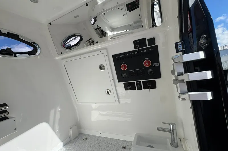 Slide: The Image of Interior view of 2026 Tidewater 302 CC Adventure boat, featuring control panel and portholes. - 35