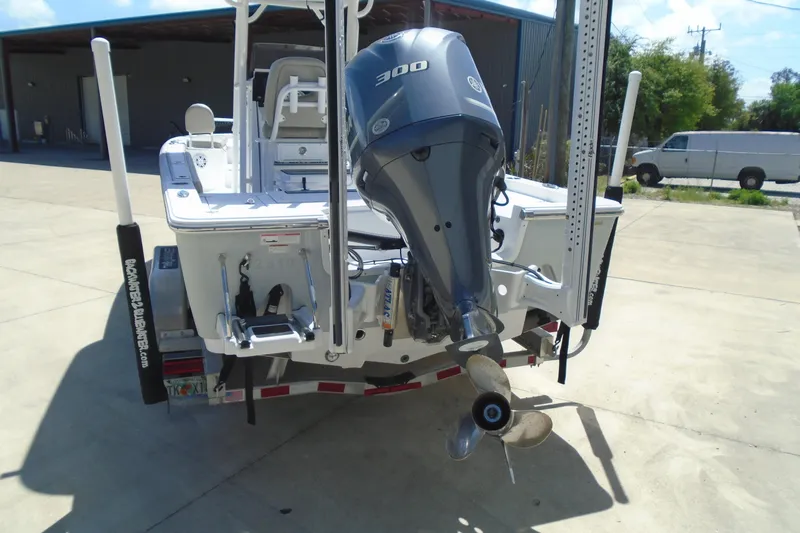 Slide: The Image of 2021 Sportsman Masters 247 Bay Boat with powerful outboard motor, parked on trailer. - 15