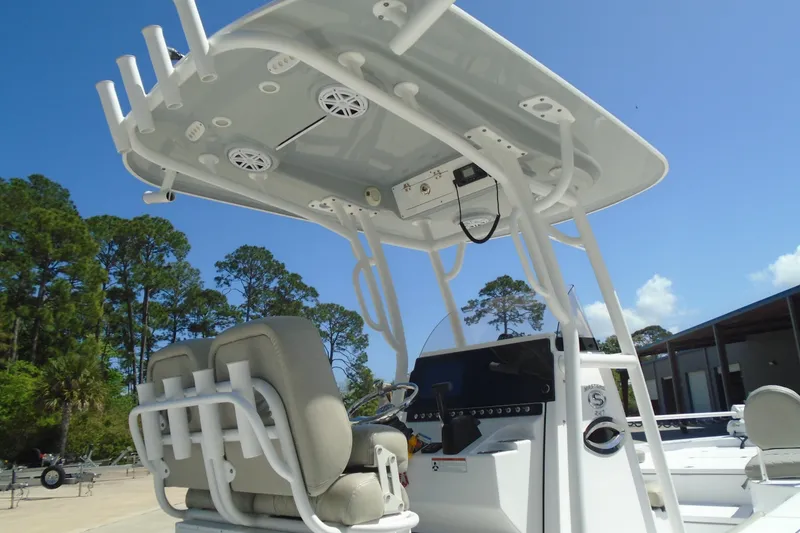 Slide: The Image of 2021 Sportsman Masters 247 Bay Boat with T-top and seating, under clear blue sky. - 17