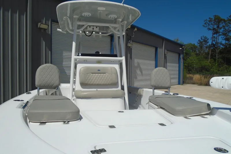 Slide: The Image of 2021 Sportsman Masters 247 Bay Boat with cushioned seating and T-top in a marina setting. - 6