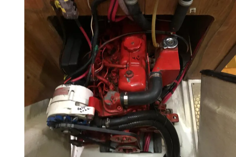 Slide: The Image of Engine compartment of a 1998 Catalina 380 sailboat, featuring red engine components and wiring. - 10