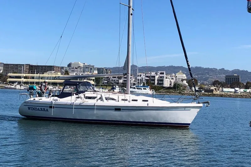Slide: The Image of 1998 Catalina 380 sailboat "Windarra" cruising in a marina with cityscape background. - 20