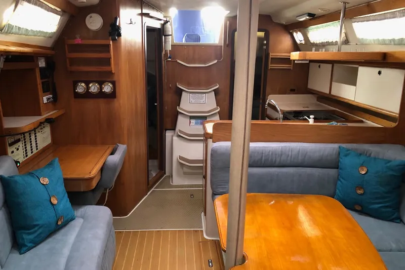 Slide: The Image of Interior of a 1998 Catalina 380 sailboat with wood finishes and cozy seating. - 9