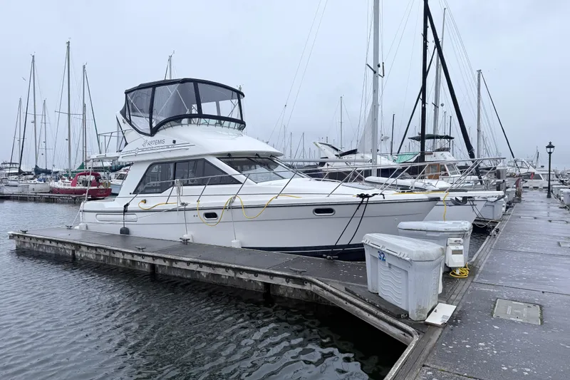The Image of 2000 Bayliner 3388 Command Bridge Motoryacht docked at a marina on a cloudy day. - 1