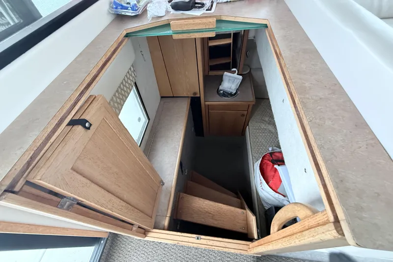 Slide: The Image of Interior view of 2000 Bayliner 3388 Command Bridge Motoryacht, showcasing wooden cabinetry and stairs. - 10
