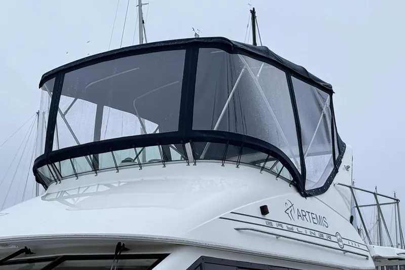 Slide: The Image of 2000 Bayliner 3388 Command Bridge Motoryacht with enclosed bridge, docked on a cloudy day. - 4