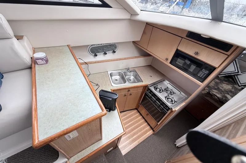 Slide: The Image of Interior of 2000 Bayliner 3388 Command Bridge Motoryacht kitchen with stove, sink, and microwave. - 6