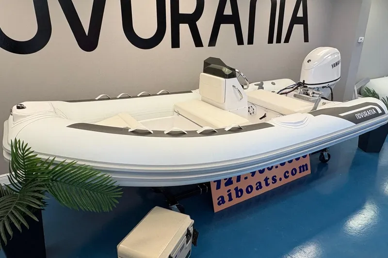 Slide: The Image of 2026 Novurania DL 430 inflatable boat with Yamaha engine displayed indoors. - 4