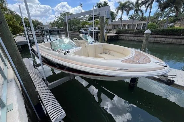 Slide: The Image of 2019 Chris-Craft Launch 27 boat docked on a lift, showcasing elegant design and teak decking. - 3