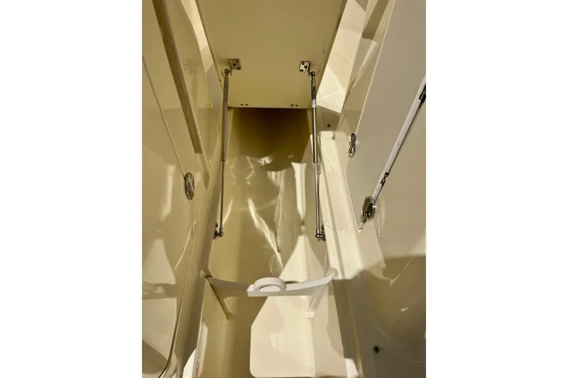 Slide: The Image of 2019 Chris-Craft Launch 27 interior storage compartment with open hatch and hydraulic supports. - 31