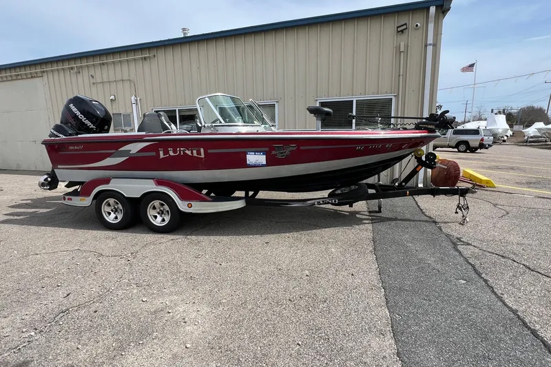 Slide: The Image of 2012 Lund 208 Pro-V GL boat on trailer, parked outside a building. - 1