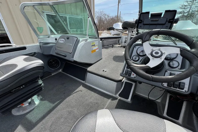 Slide: The Image of Interior of a 2012 Lund 208 Pro-V GL boat, featuring steering wheel and seating. - 11