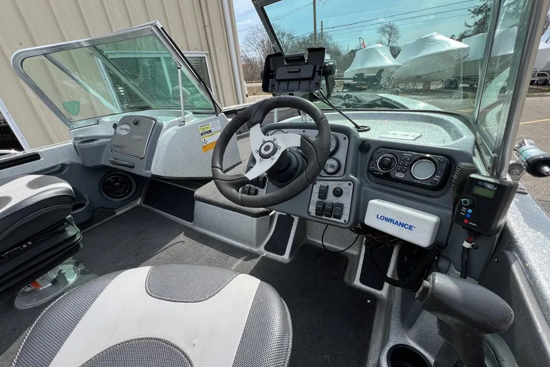 Slide: The Image of 2012 Lund 208 Pro-V GL boat cockpit with steering wheel and navigation equipment. - 15