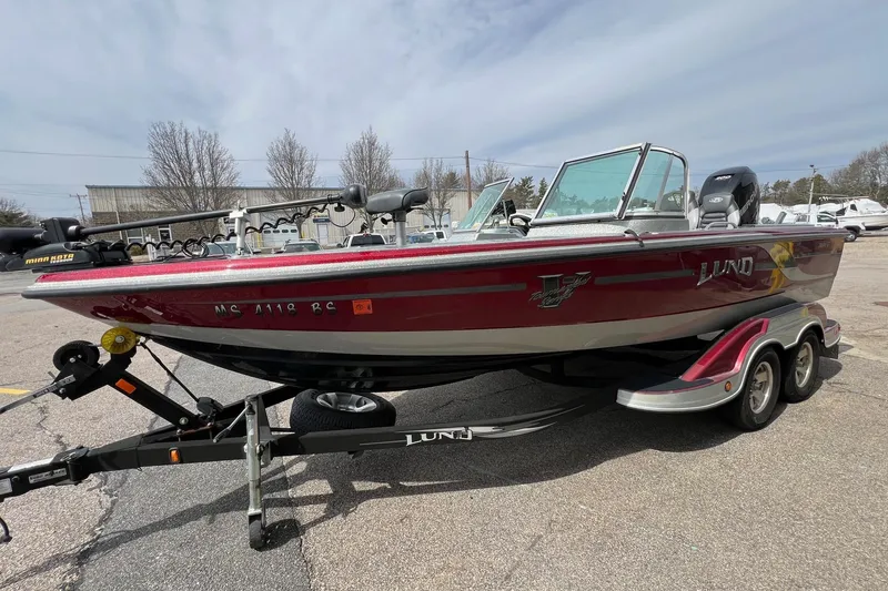 Slide: The Image of 2012 Lund 208 Pro-V GL boat on trailer, parked outdoors under cloudy sky. - 5
