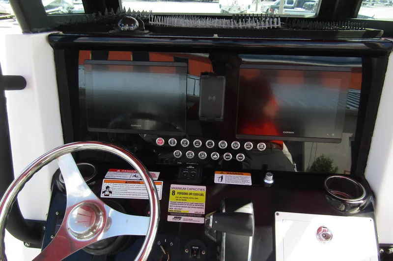 Slide: The Image of 2024 Wellcraft 223 Fisherman dashboard with dual Garmin displays and steering wheel. - 11