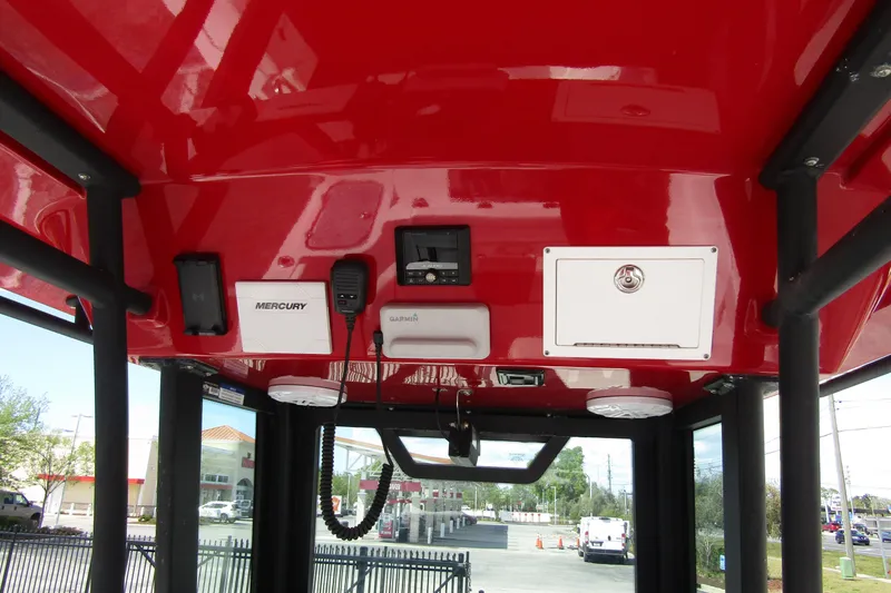 Slide: The Image of 2024 Wellcraft 223 Fisherman boat interior with red ceiling and electronic controls. - 12