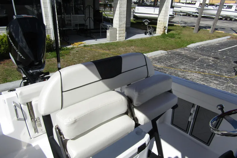 Slide: The Image of 2024 Wellcraft 223 Fisherman boat interior with white seating and Mercury engine. - 14