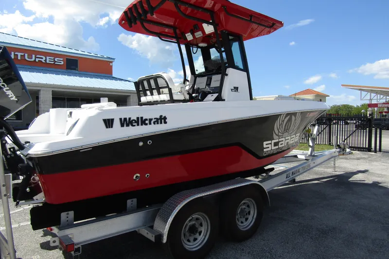 Slide: The Image of 2024 Wellcraft 223 Fisherman boat on trailer, red and black design, outdoor display. - 3
