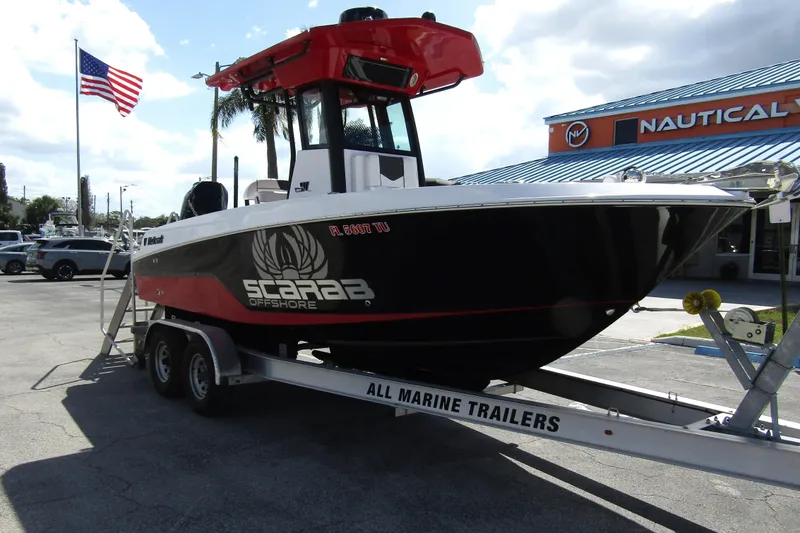 Slide: The Image of 2024 Wellcraft 223 Fisherman boat on trailer, displayed outdoors with American flag. - 5
