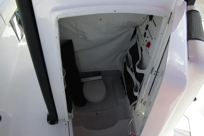 Slide: The Image of 2024 Wellcraft 223 Fisherman boat interior with compact marine toilet and storage. - 9