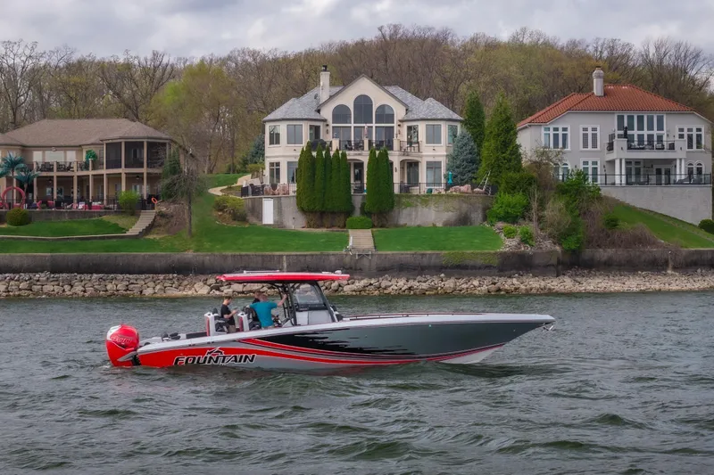 The Image of 2021 Fountain 38 SC boat cruising near luxurious waterfront homes. - 1