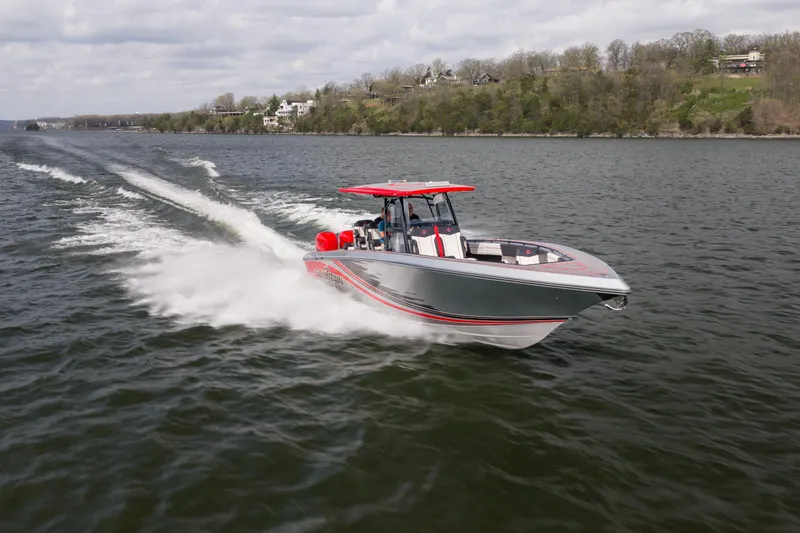 Slide: The Image of 2021 Fountain 38 SC speedboat cruising on a lake with scenic shoreline. - 10