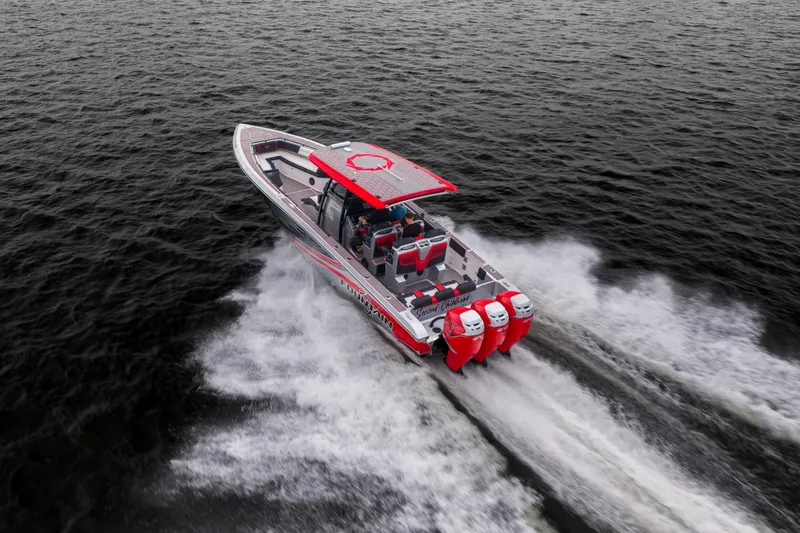 Slide: The Image of 2021 Fountain 38 SC boat speeding on water with triple outboard engines. - 12