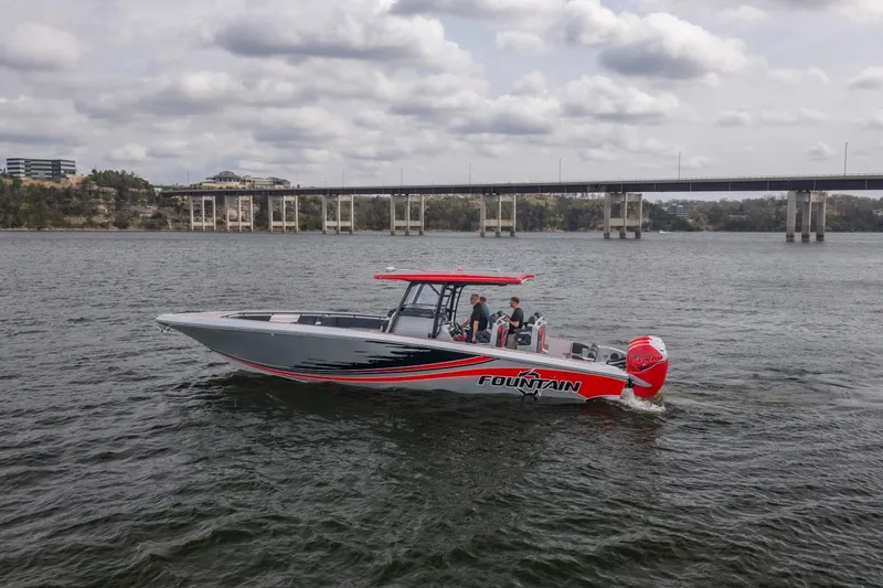 Slide: The Image of 2021 Fountain 38 SC boat cruising on a river near a bridge under cloudy skies. - 3