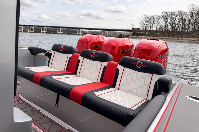 Slide: The Image of 2021 Fountain 38 SC boat with red and white seating, powerful engines, on a scenic river. - 35