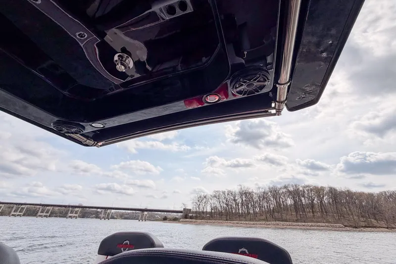 Slide: The Image of 2021 Fountain 38 SC boat interior with speakers, overlooking a scenic river and bridge. - 40