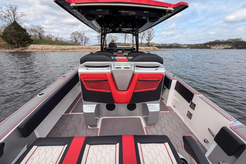 Slide: The Image of 2021 Fountain 38 SC boat interior with red and black seating on a calm lake. - 42