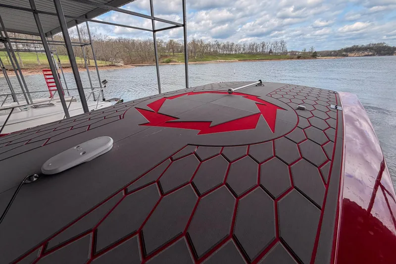 Slide: The Image of 2021 Fountain 38 SC boat with hexagonal deck pattern, docked by a scenic lake. - 46