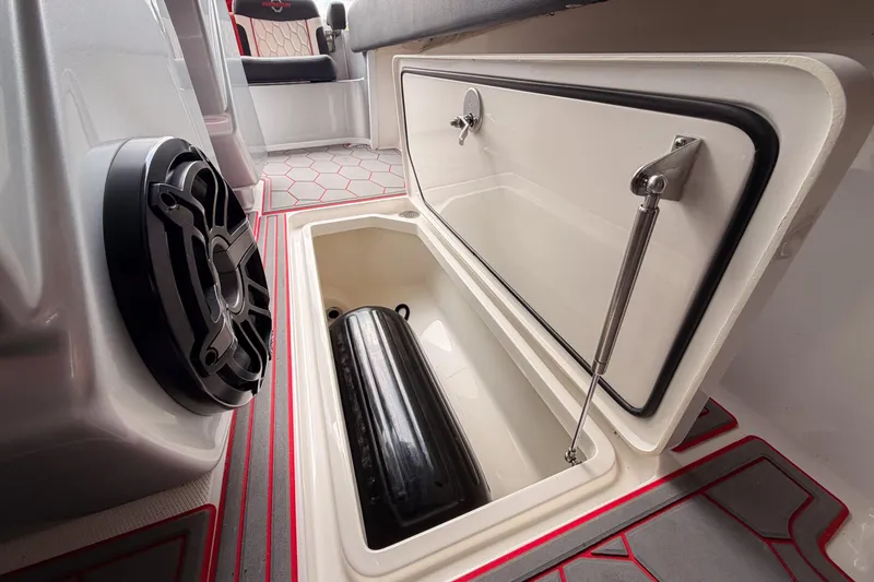 Slide: The Image of 2021 Fountain 38 SC boat storage compartment with speaker and red-accented flooring. - 48