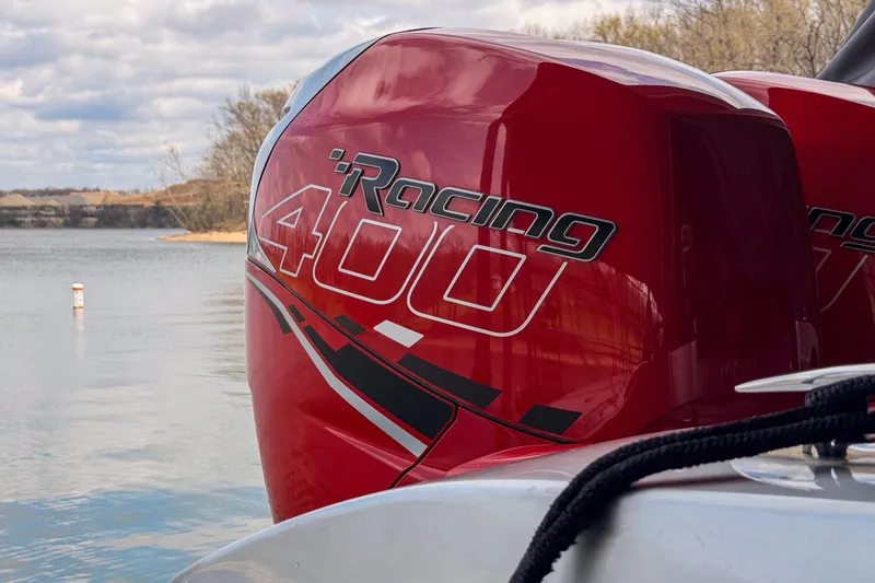 Slide: The Image of Red Racing 400 engine on 2021 Fountain 38 SC boat by a lake. - 55