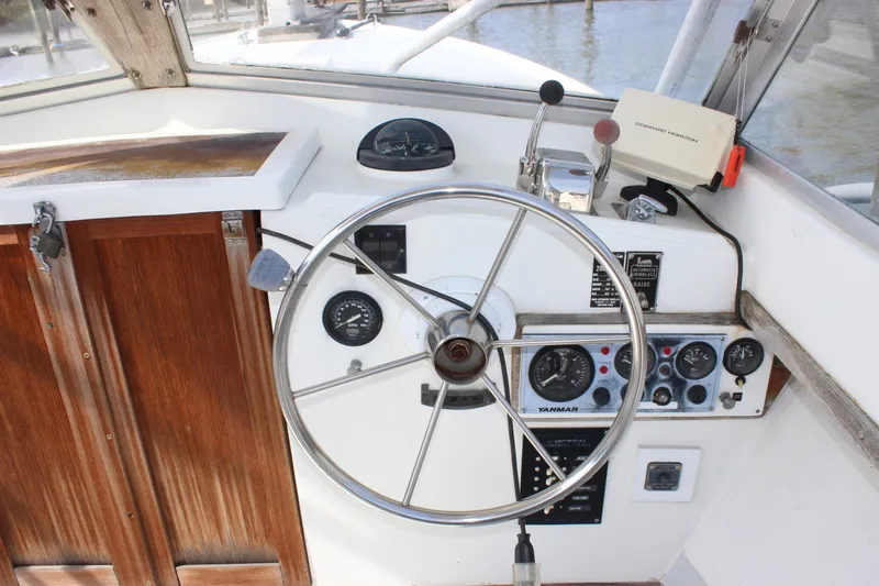 Slide: The Image of 1979 Tripp Angler 22 Flush Deck Cuddy helm with steering wheel and control panel. - 10
