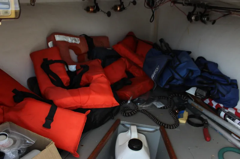 Slide: The Image of Storage area of 1979 Tripp Angler boat with life jackets and fishing gear. - 16