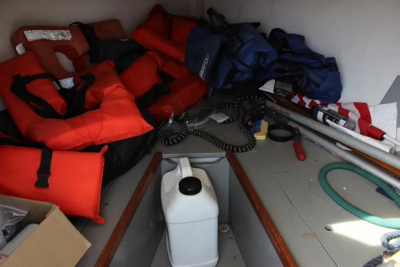 Slide: The Image of Interior of 1979 Tripp Angler boat with life jackets and boating equipment. - 19