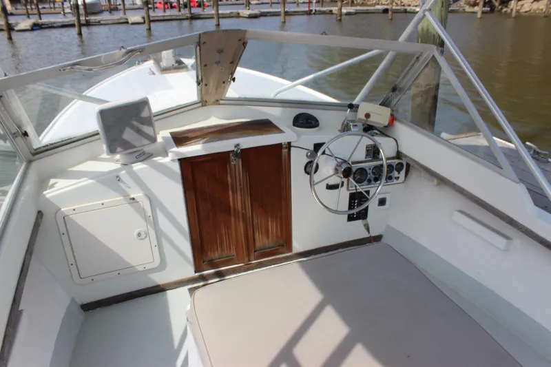 Slide: The Image of 1979 Tripp Angler 22 Flush Deck Cuddy boat interior with steering wheel and controls. - 8