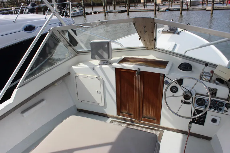 Slide: The Image of 1979 Tripp Angler 22 Flush Deck Cuddy boat interior with steering wheel and control panel. - 9