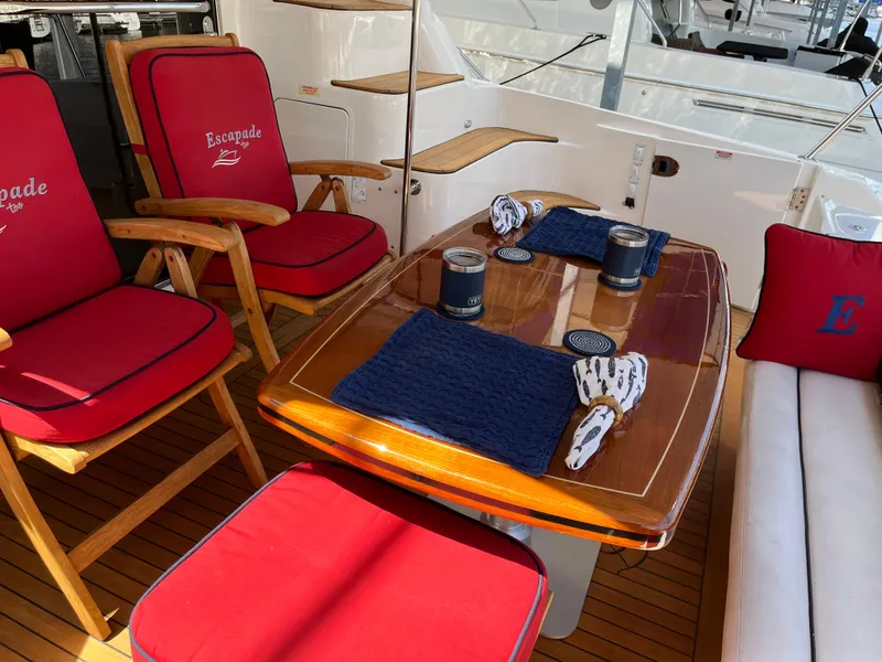 Slide: The Image of Luxurious 2007 Sea Ray 58 Sedan Bridge yacht interior with red cushioned seating and wooden table. - 10
