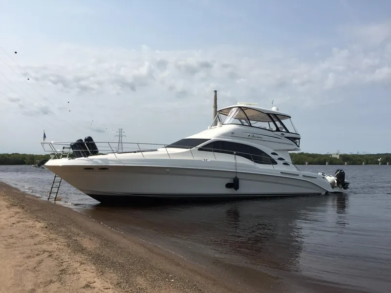 Slide: The Image of 2007 Sea Ray 58 Sedan Bridge yacht docked on a calm riverbank. - 2