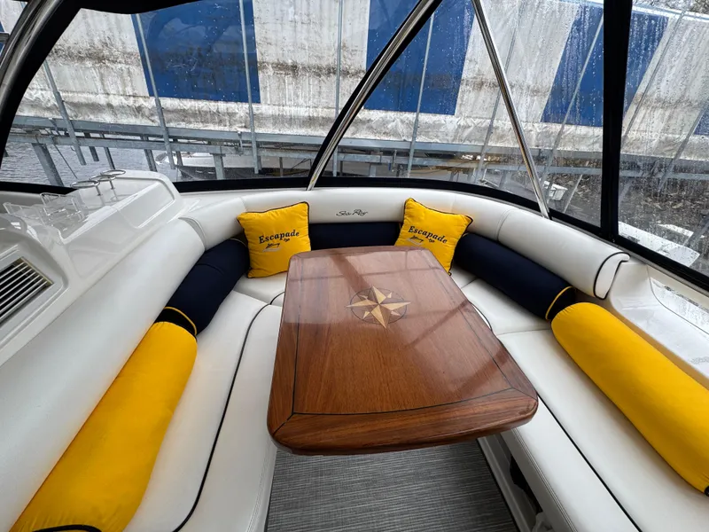 Slide: The Image of 2007 Sea Ray 58 Sedan Bridge interior with cushioned seating and wooden table. - 28