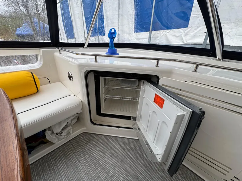 Slide: The Image of 2007 Sea Ray 58 Sedan Bridge interior with open mini fridge and seating area. - 32