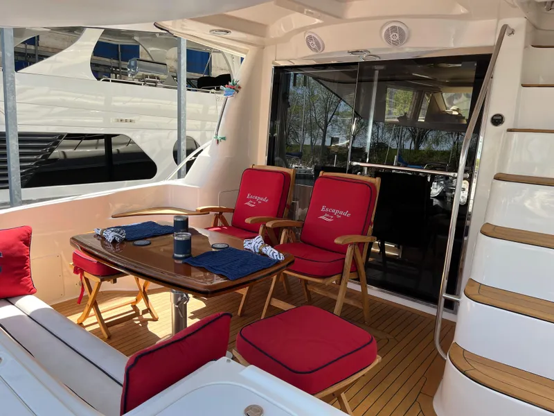 Slide: The Image of 2007 Sea Ray 58 Sedan Bridge yacht with outdoor dining area and red cushioned seating. - 8