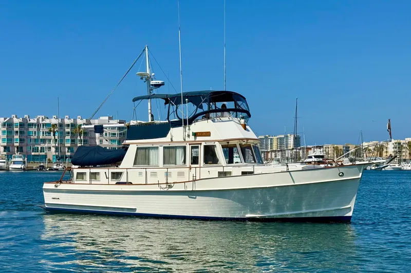The Image of 1992 Grand Banks 46 Classic yacht on calm water, with modern buildings in the background. - 0
