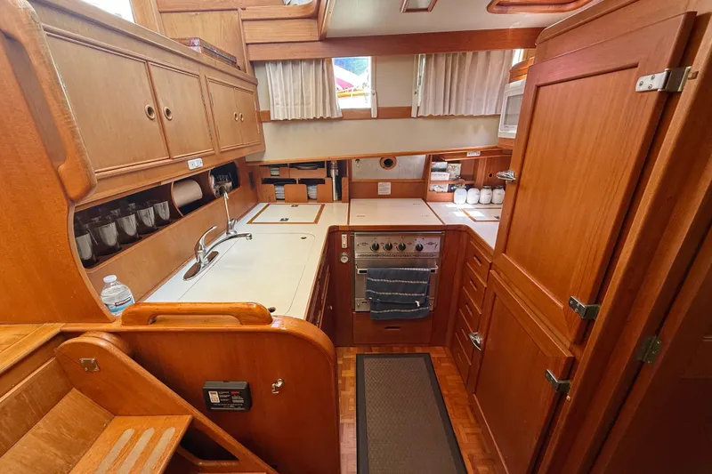 Slide: The Image of 1992 Grand Banks 46 Classic yacht kitchen with wooden cabinetry and modern appliances. - 27