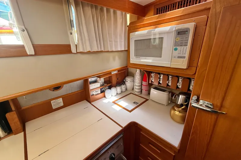 Slide: The Image of 1992 Grand Banks 46 Classic yacht kitchen with microwave, toaster, and wooden cabinetry. - 29