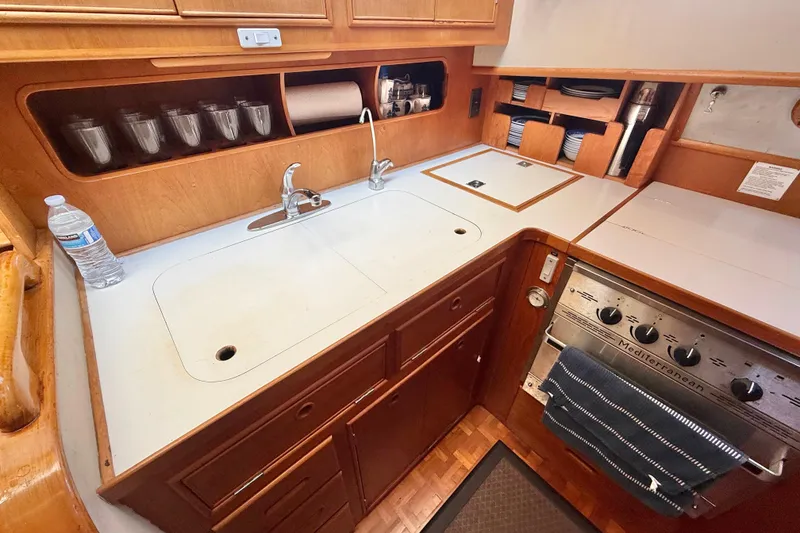 Slide: The Image of Grand Banks 46 Classic 1992 yacht kitchen with sink, stove, and storage shelves. - 30